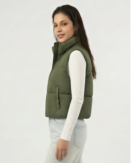 Woman wearing a green puffer vest on a white background