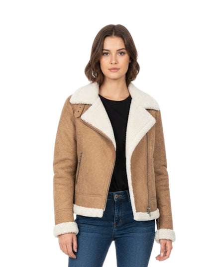 Woman wearing a brown shearling jacket with white lining on a white background