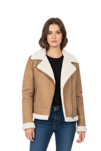 Woman wearing a brown shearling jacket with white lining on a white background