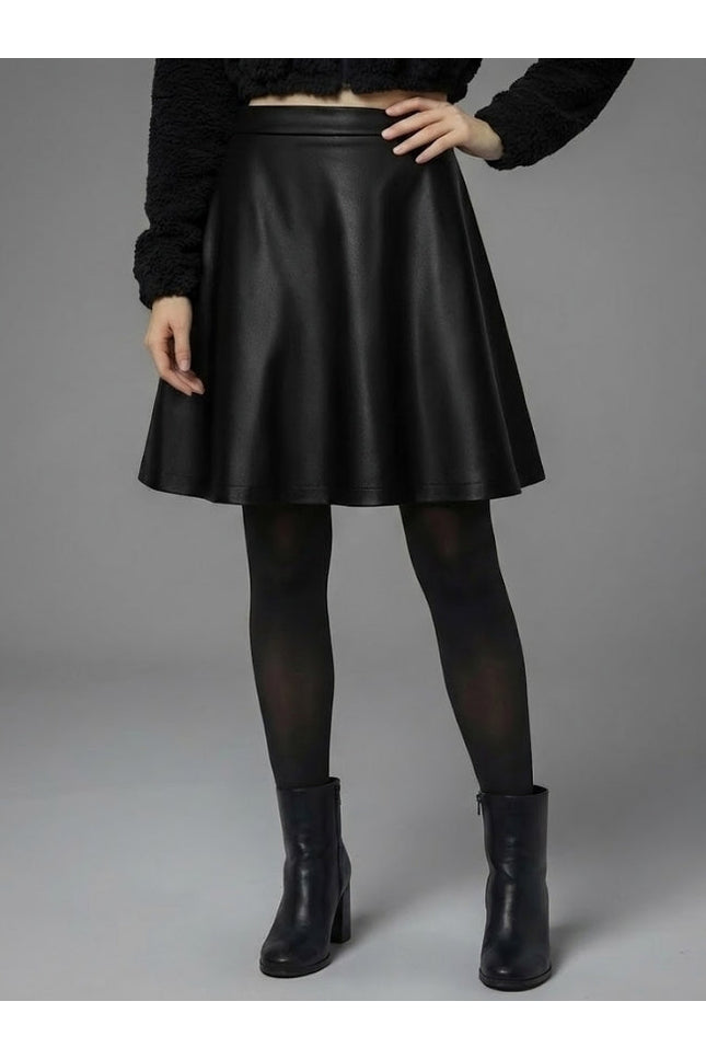 Person wearing a black leather skirt with black tights and boots on a gray background