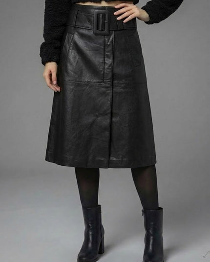 Person wearing a black leather skirt with a belt on a gray background