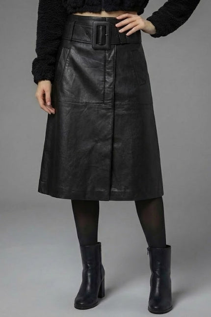 Person wearing a black leather skirt with a belt on a gray background