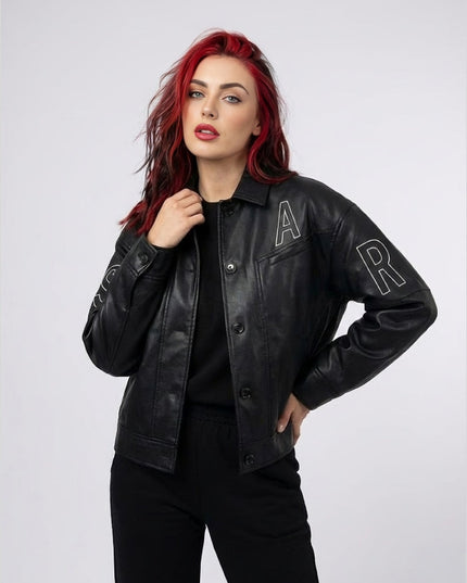 Woman wearing a black leather jacket with 'A' and 'R' patches on a white background