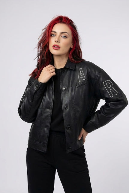 Woman wearing a black leather jacket with 'A' and 'R' patches on a white background