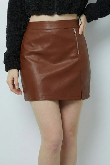 Brown leather skirt worn by a person on a white background