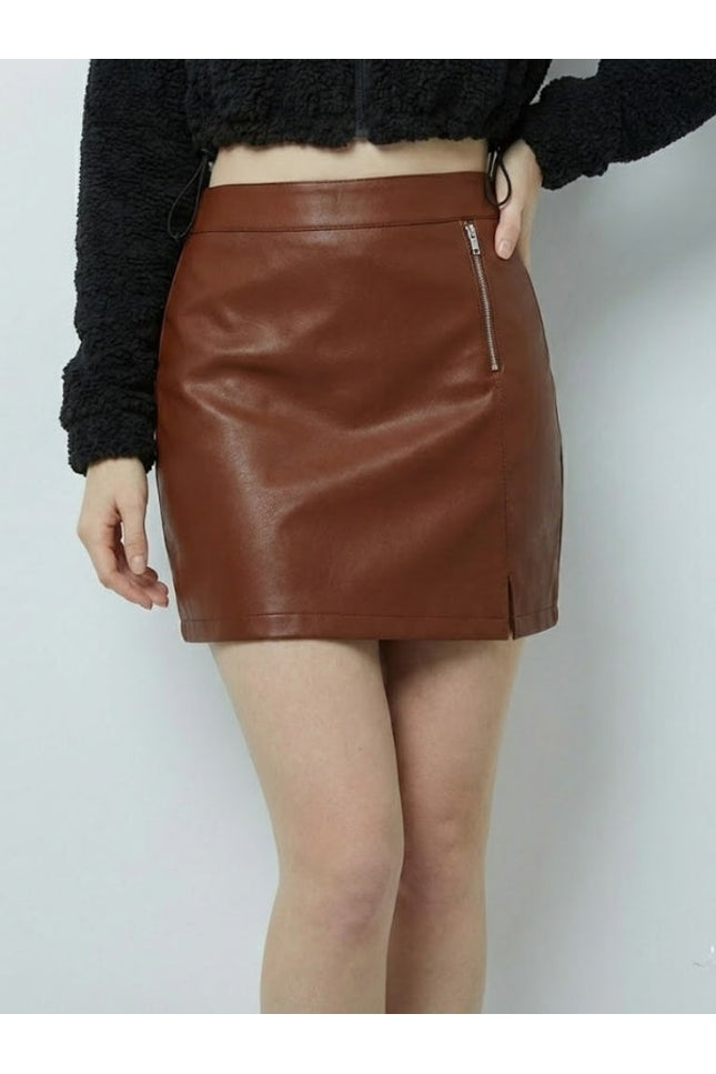 Brown leather skirt worn by a person on a white background