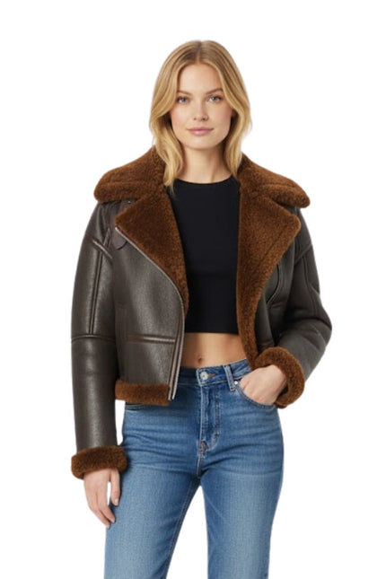 Woman wearing a brown leather jacket with fur trim on a white background