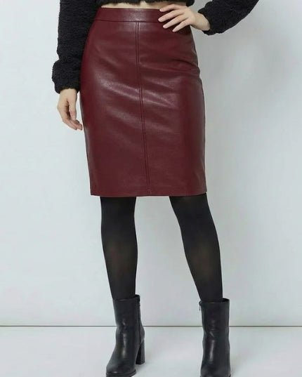 Person wearing a burgundy leather skirt with black tights and boots on a white background