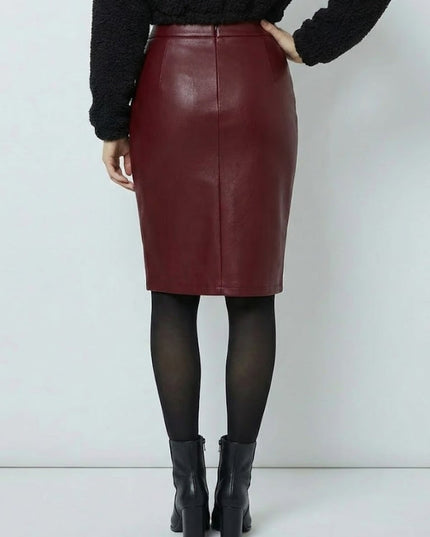 Person wearing a burgundy leather skirt with black tights and boots on a white background