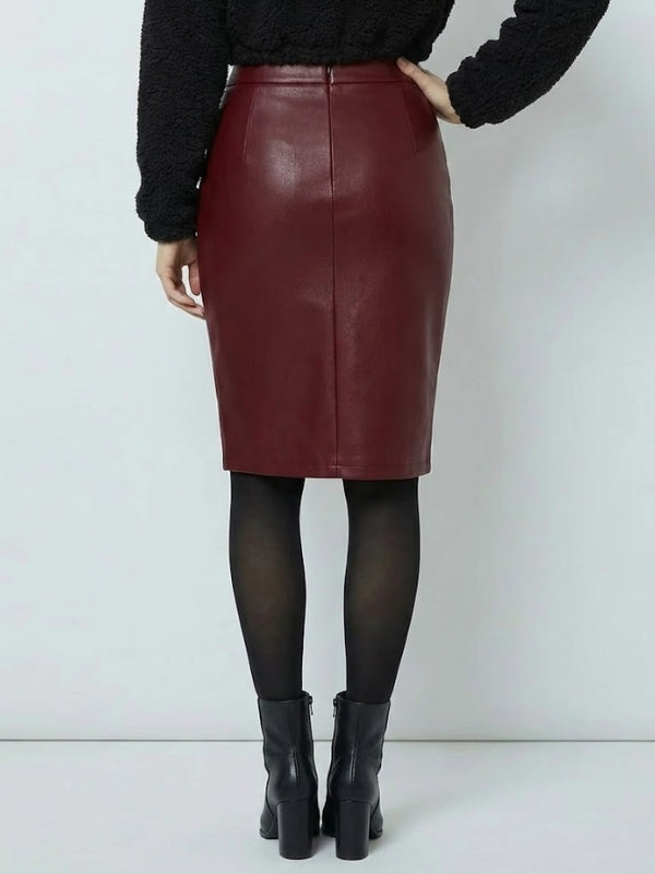 Person wearing a burgundy leather skirt with black tights and boots on a white background