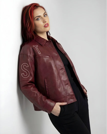 Woman wearing a maroon leather jacket with 'ST' lettering on a white background