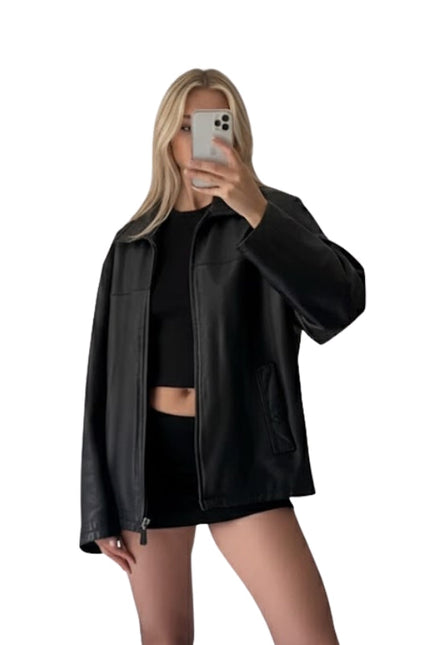 Person wearing a black leather jacket and black outfit on a white background