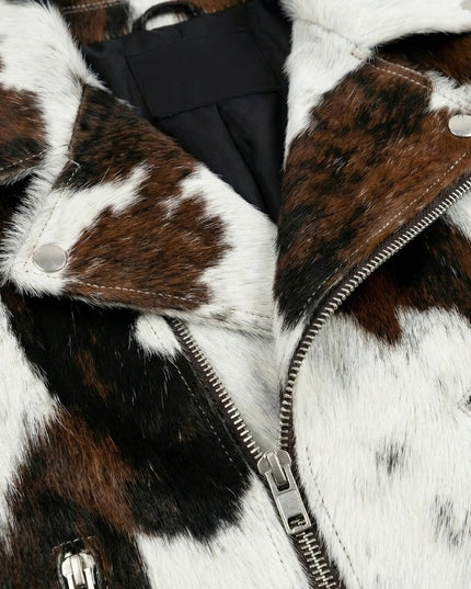 Close-up of a fur coat with a zipper, featuring brown, white, and black patches.