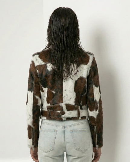 Person wearing a cowhide pattern jacket on a plain background