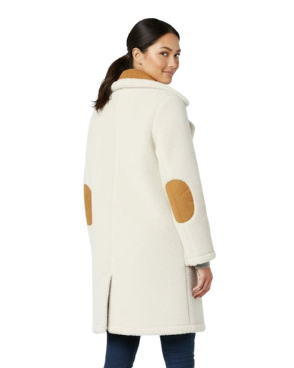 Woman wearing a cream coat with brown patchwork on a white background