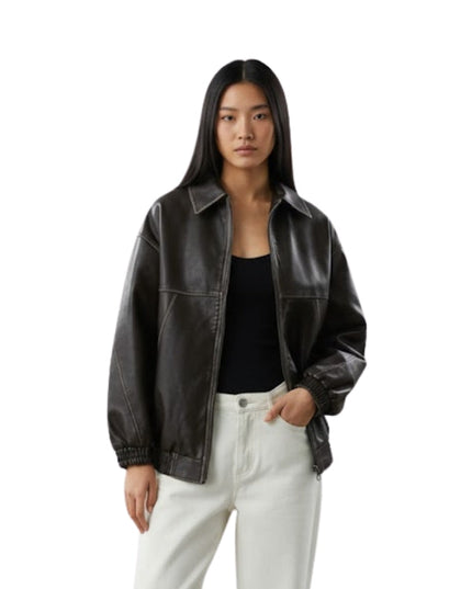Woman wearing a black leather jacket and white pants on a white background