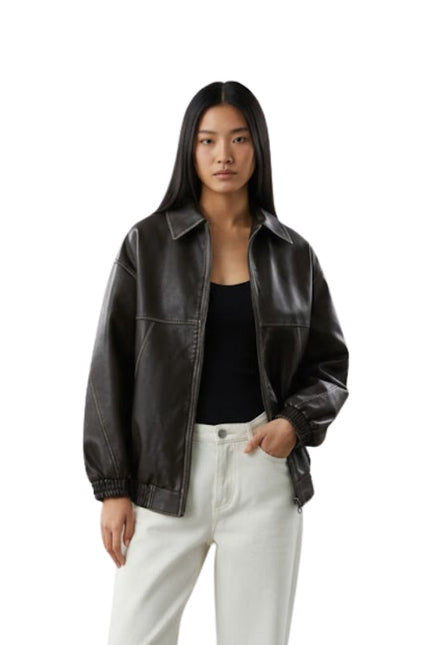 Woman wearing a black leather jacket and white pants on a white background