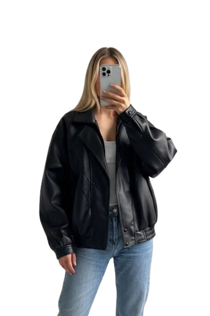 Person wearing a black leather jacket and blue jeans on a white background