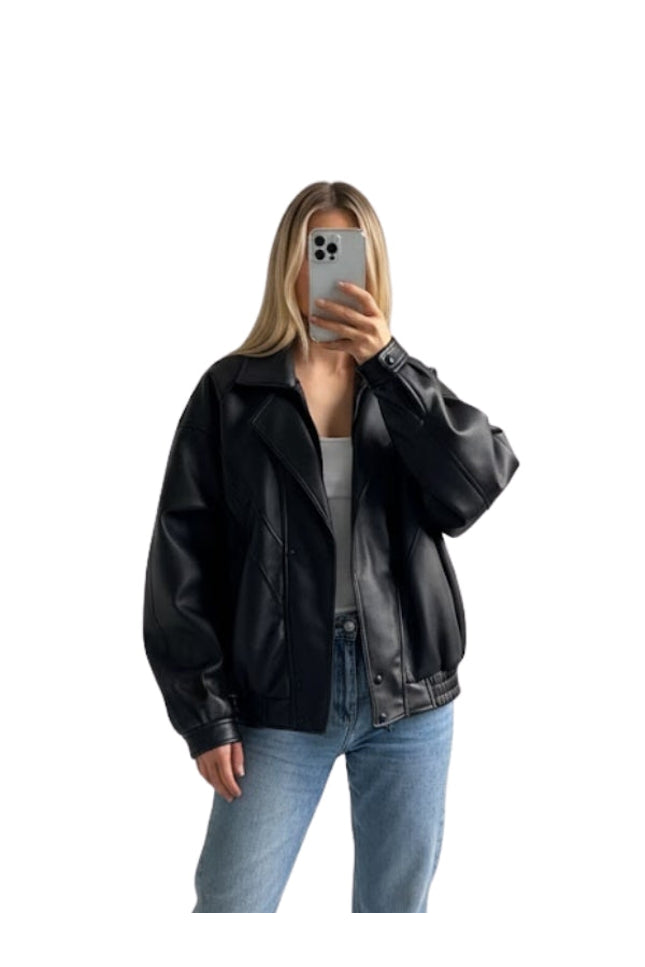 Person wearing a black leather jacket and blue jeans on a white background