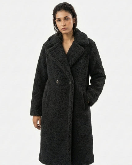 Woman wearing a black coat on a white background