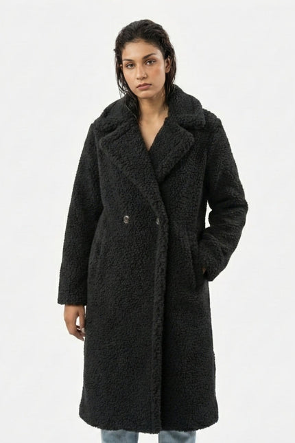 Woman wearing a black coat on a white background