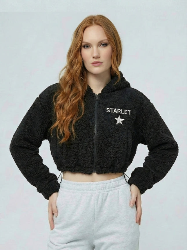 Woman wearing a black 'STARLET' hoodie with a white star logo on a light gray background