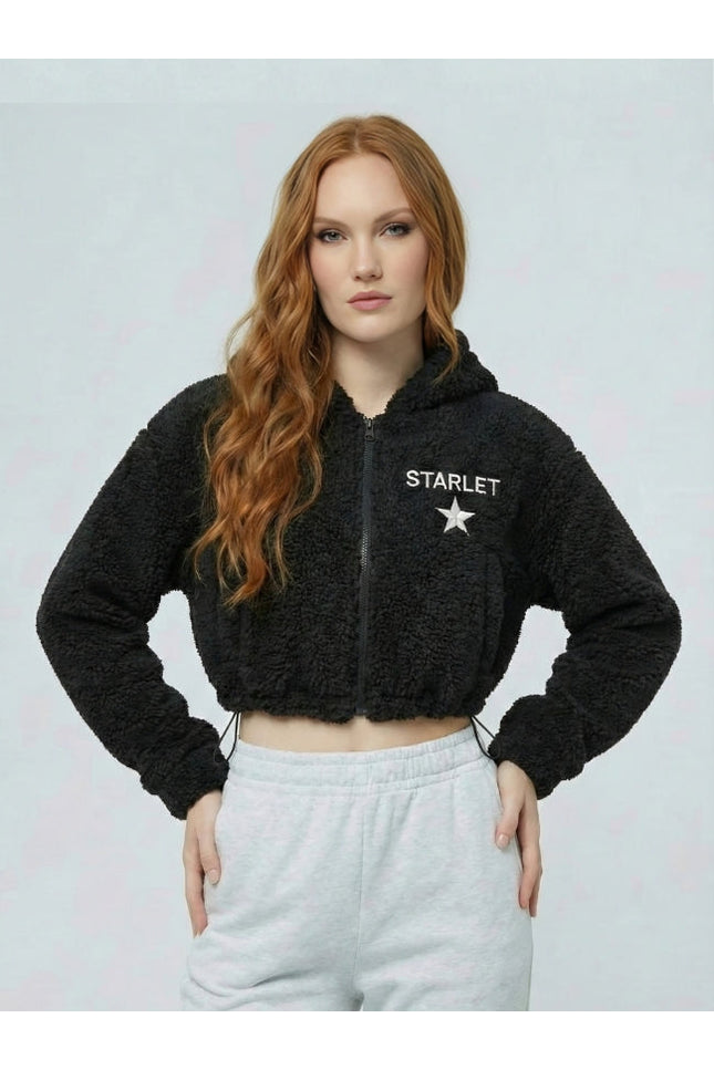 Woman wearing a black 'STARLET' hoodie with a white star logo on a light gray background