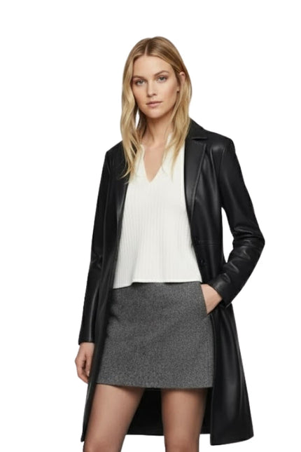 Woman wearing a black leather coat over a white top and gray skirt on a white background