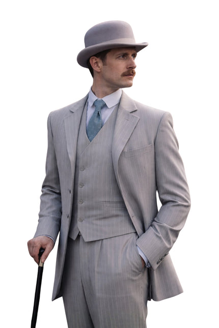 Man in a gray suit and hat holding a cane on a white background