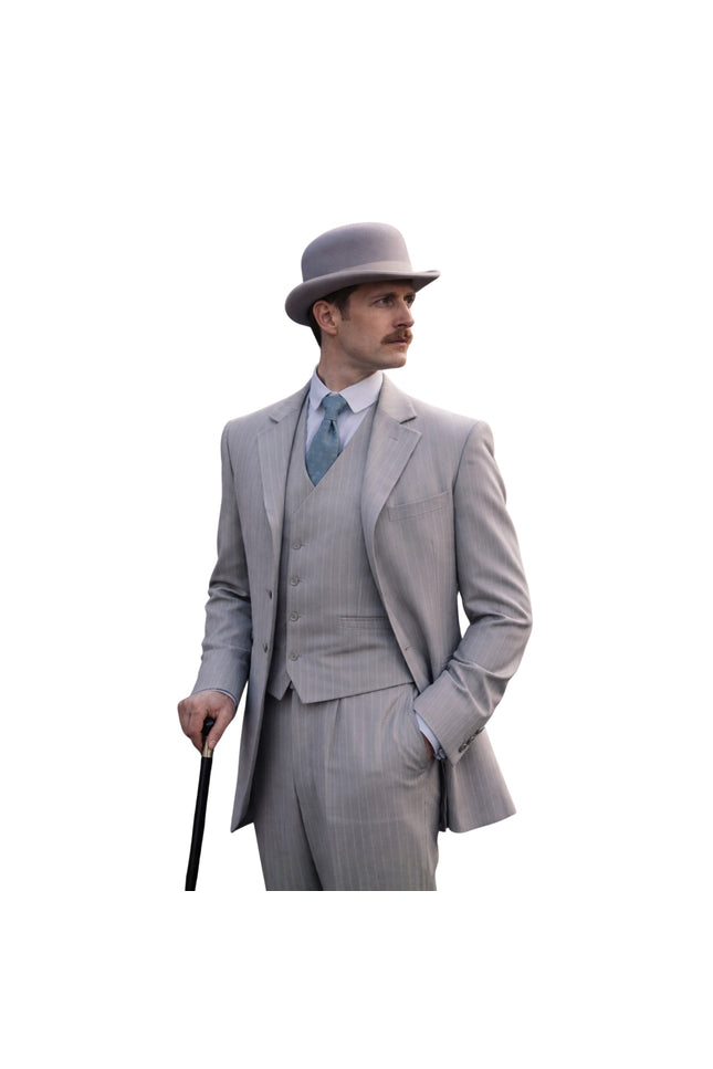 Man in a gray suit and hat holding a cane on a white background