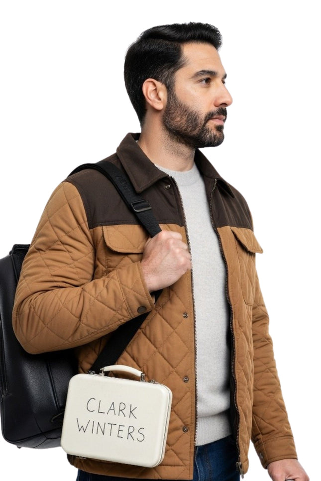 Man holding a black backpack and a white bag with 'Clark Winters' branding on a white background