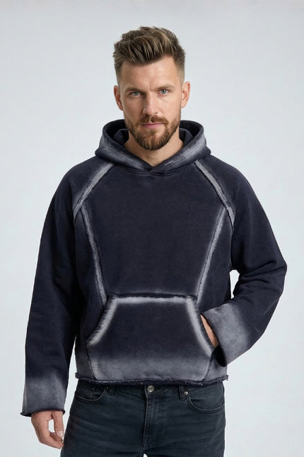 Man wearing a dark gray hoodie with a light gray gradient on a light gray background